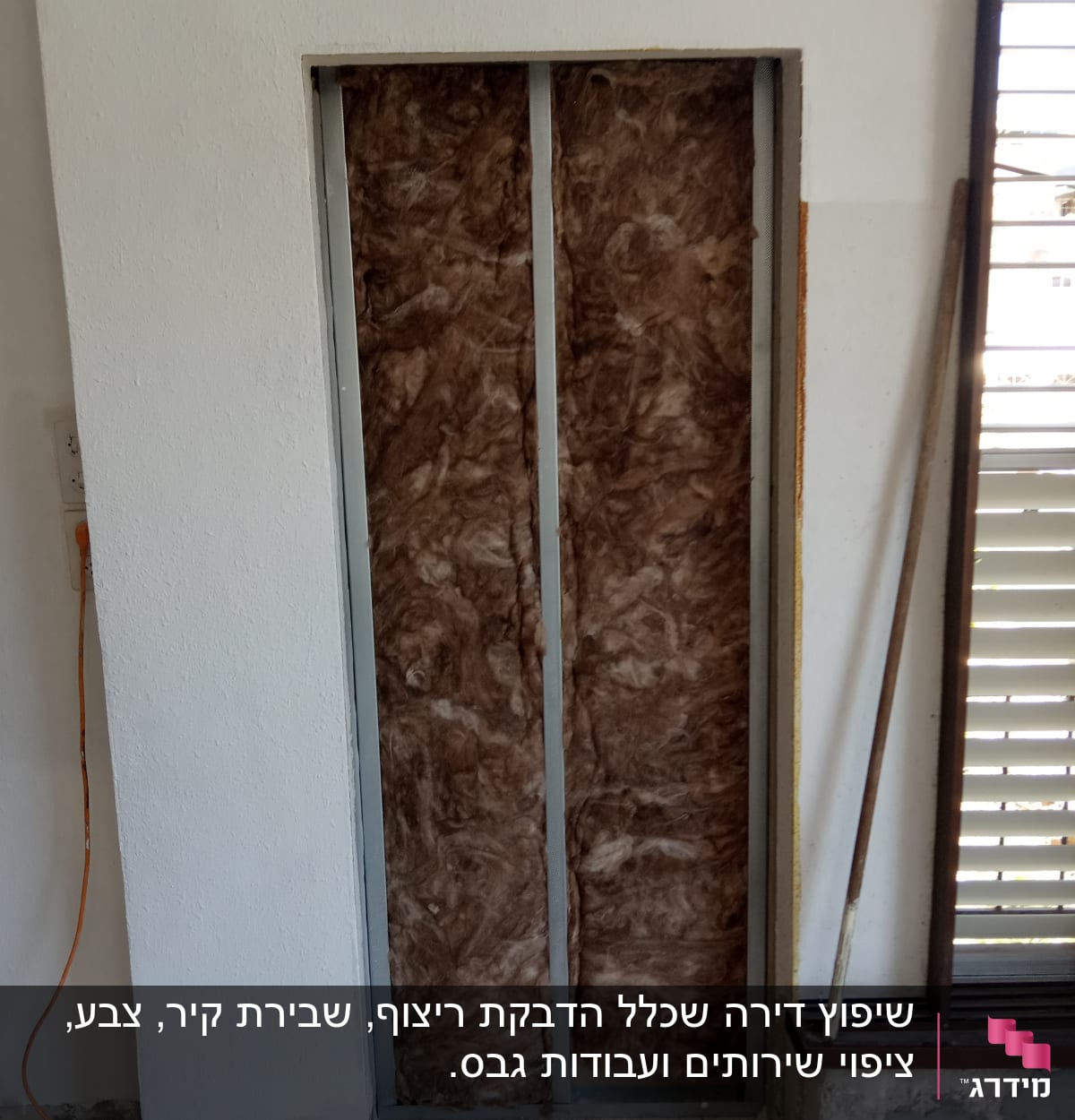 קיר עם בידוד פיברגלס במסגרת מתכת במהלך שיפוץ